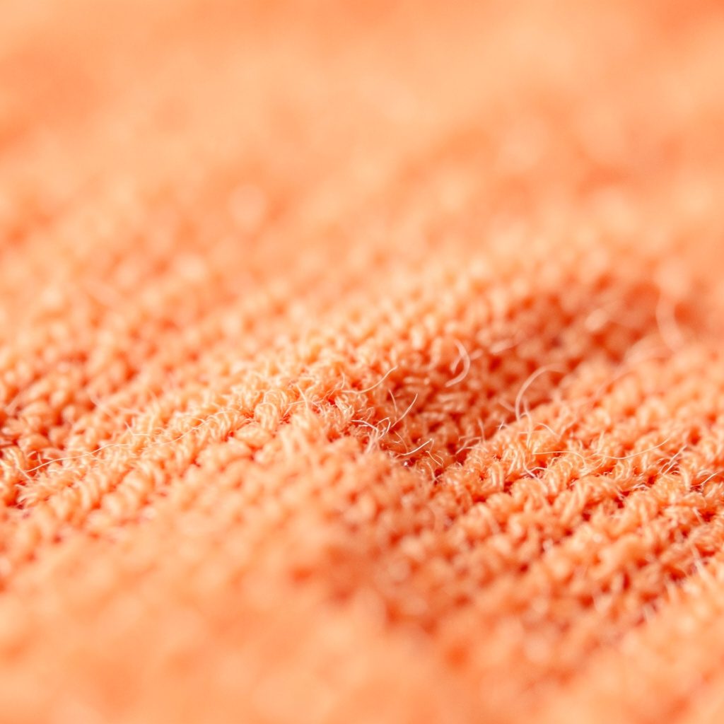 Tight crop of a warm wheat-colored plaster wall with soft shadows along the edges.