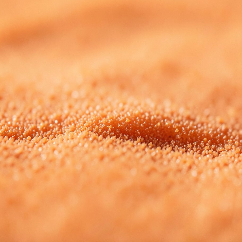 Close-up of a warm tan fibrous paper texture with soft grain and amber highlights.